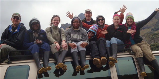Group of students sitting on top of a vehicle