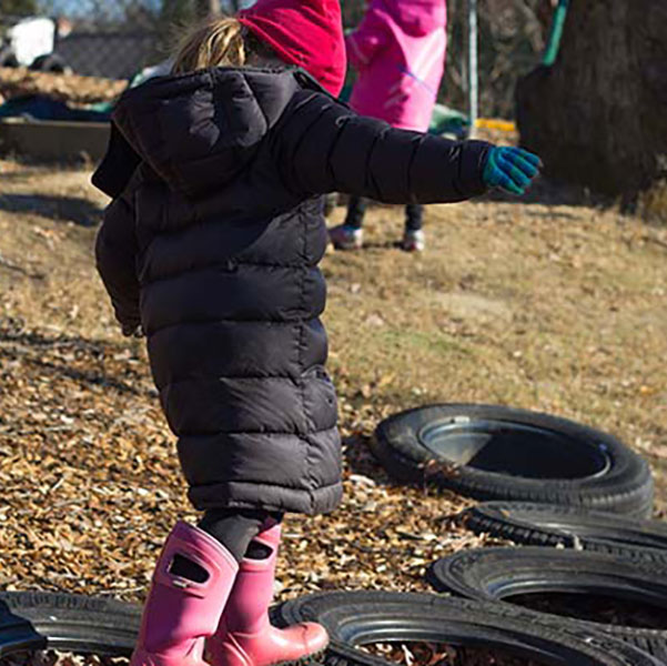 preschool child walking on tires
