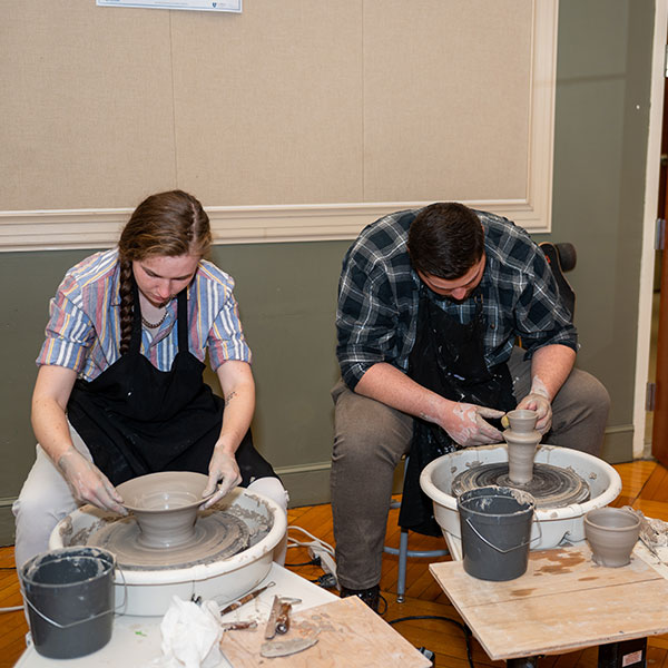 two students making pottery