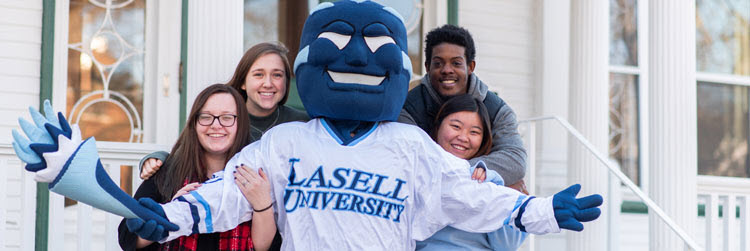 The Lasell mascot named Boomer stands with students 