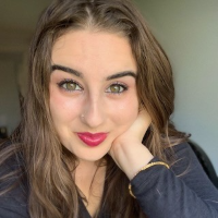 a smiling queer biracial Iranian American woman