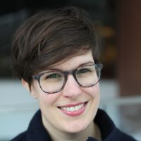 a smiling white woman with glasses and a short haircut