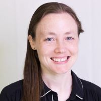 a smiling white woman against a solid background