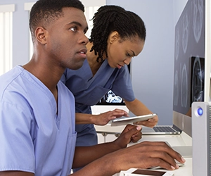 two medical professionals looking at computer monitor