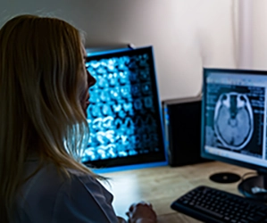 female medical professional monitoring neuro images on computers