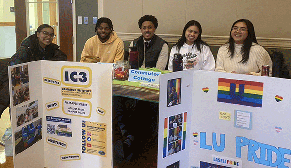 students at activities fair table with poster