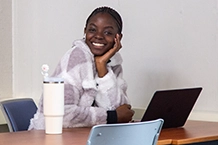 a Lasell student working on a computer at a desk