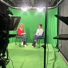 Two students filming at Lasell's tv studio