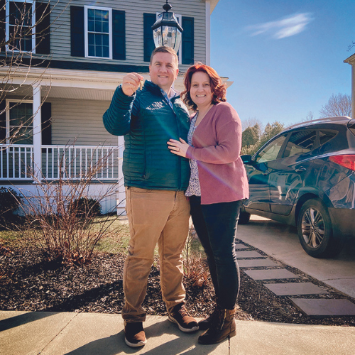 Rachel Howard '09 and husband in front of their new home