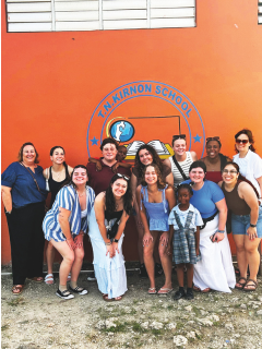 Lasell University students and faculty on a Shoulder to Shoulder trip to Antigua, pictured with local Antiguan students