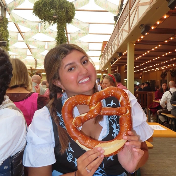 female student on study abroad in munich with a large pretzel
