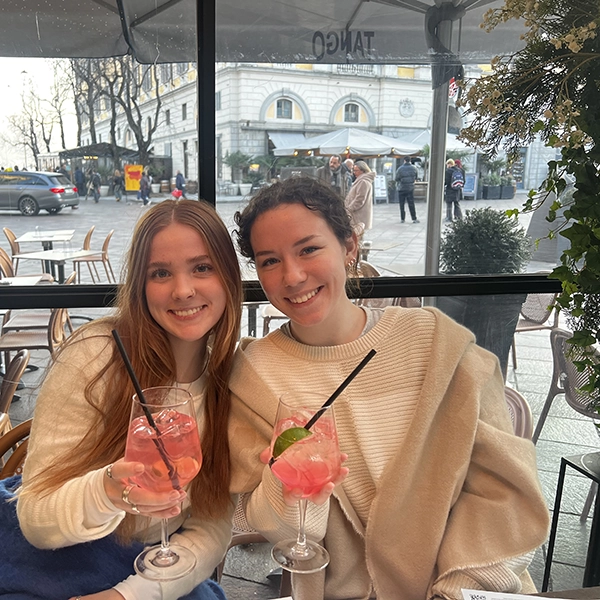 two female students on study abroad drinking pink drinks with straws