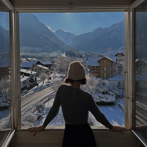 study abroad student looking out a window looking at mountains