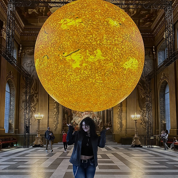 student on study abroad with a yellow globe above her
