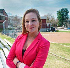 Student outside, standing next to baseball field
